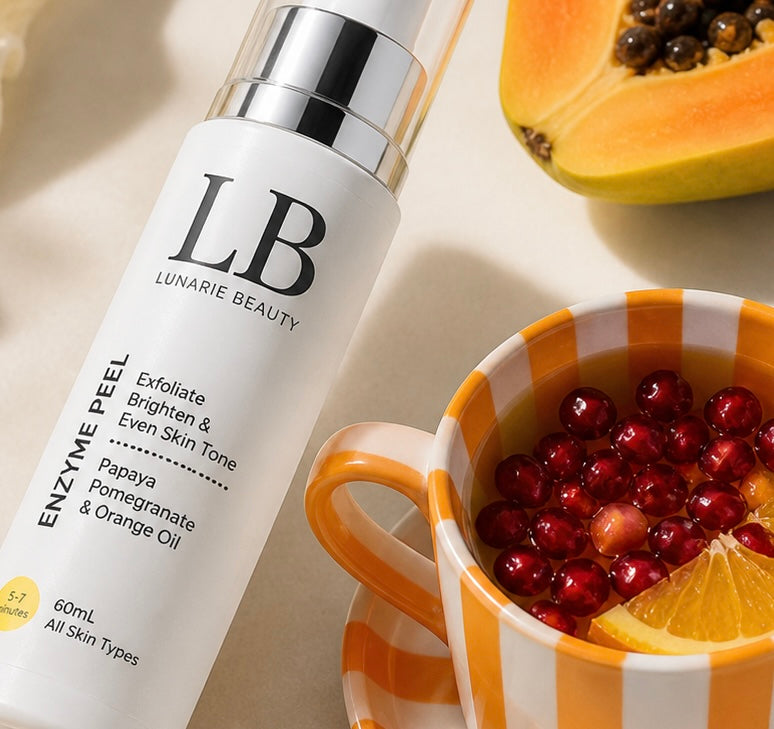 LB Lunarie Beauty enzyme peel bottle with a cup of pomegranate seeds and papaya on a light background