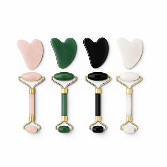Set of facial tools including gua sha tools and rollers on a white background