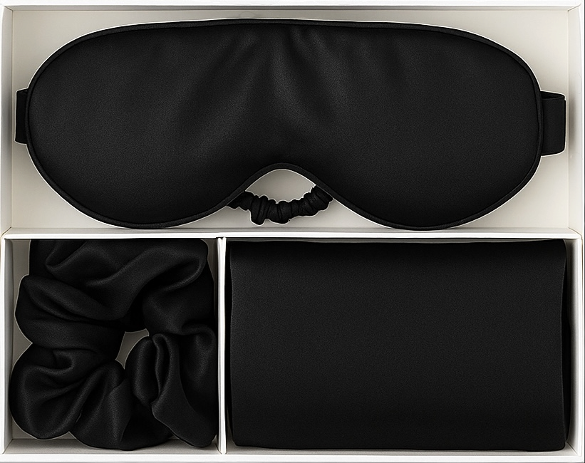 Black sleep mask, hair tie, and face mask in a box